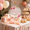 A display of pink floral thank you hand fans and gift boxes on a white table with pink ribbon accents.