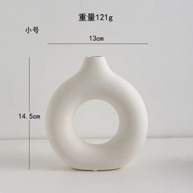 A white, smooth, organic-shaped vase with a wide opening, shown against a white background.