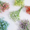 A collection of artificial baby's breath flowers in various colors including pink, yellow, white, and purple.