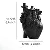 A black heart-shaped resin sculpture used as a tabletop decoration.
