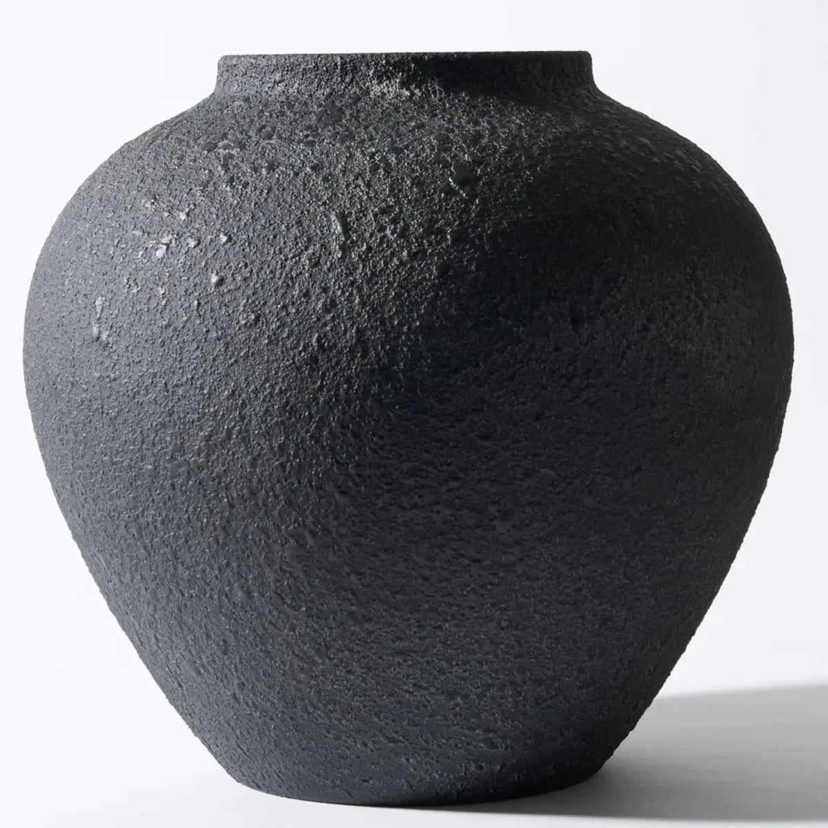 A large matte black decorative vase with an organic, rounded shape.