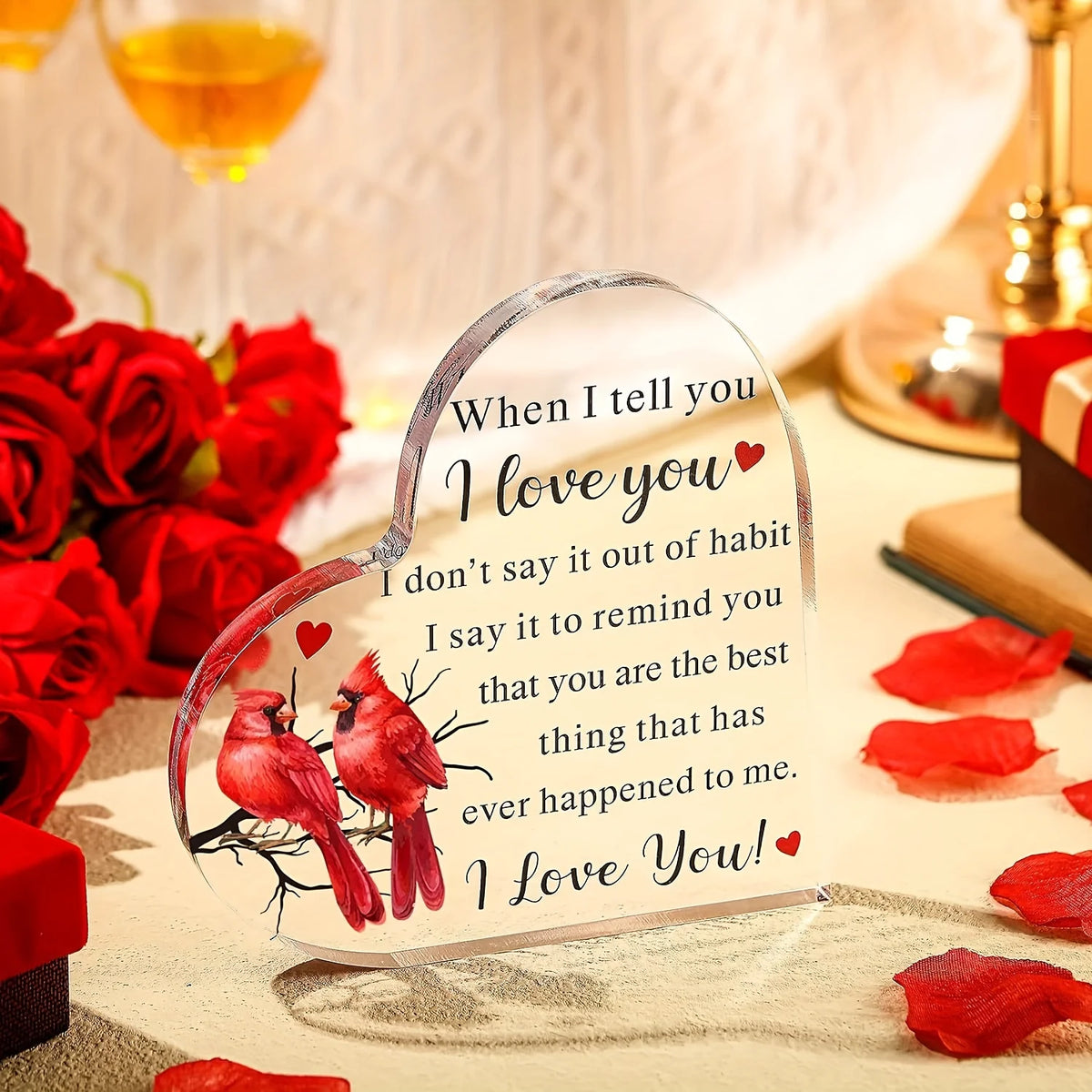 A clear heart-shaped acrylic keepsake with a red bird design and the text I love you