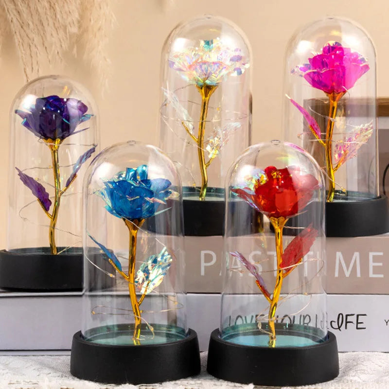A collection of eternal roses in glass domes with LED lights displayed on a white surface.