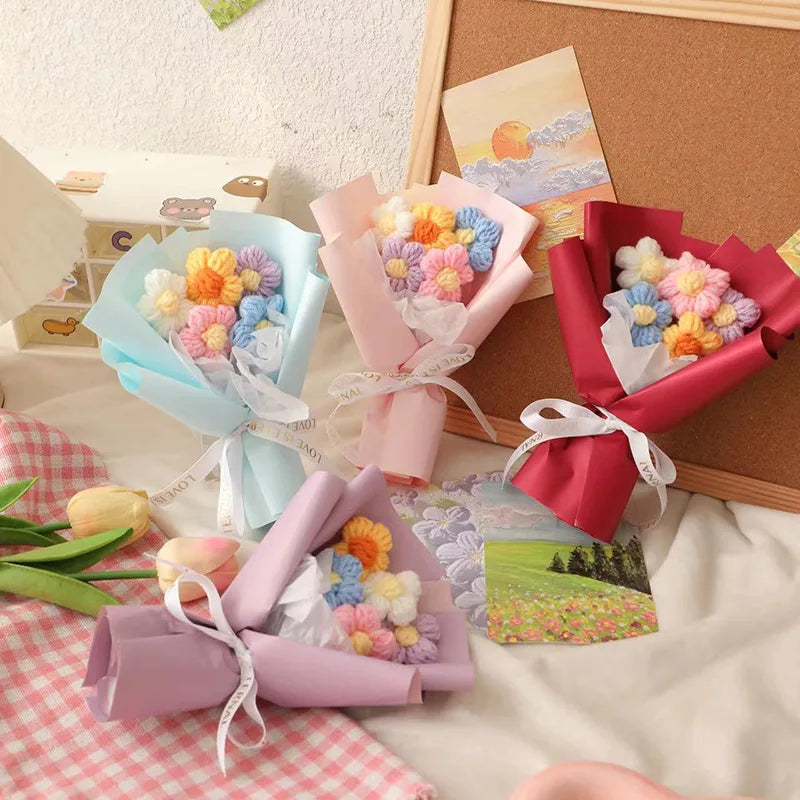 A collection of handmade crochet flower bouquets in various pastel colors, including pink, blue, and yellow, displayed on a l
