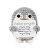 A gray crocheted penguin plush holding a white card with the text Positive penguin I may be a tiny penguin but I believe in y