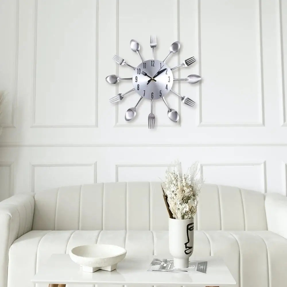 A modern cutlery 3D wall clock with silver forks and knives mounted on a white wall above a white sofa.