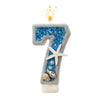 A number seven candle decorated with blue glitter and starfish accents.