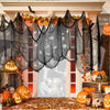 Black creepy gauze cloth draped over an orange floral garland for Halloween decor