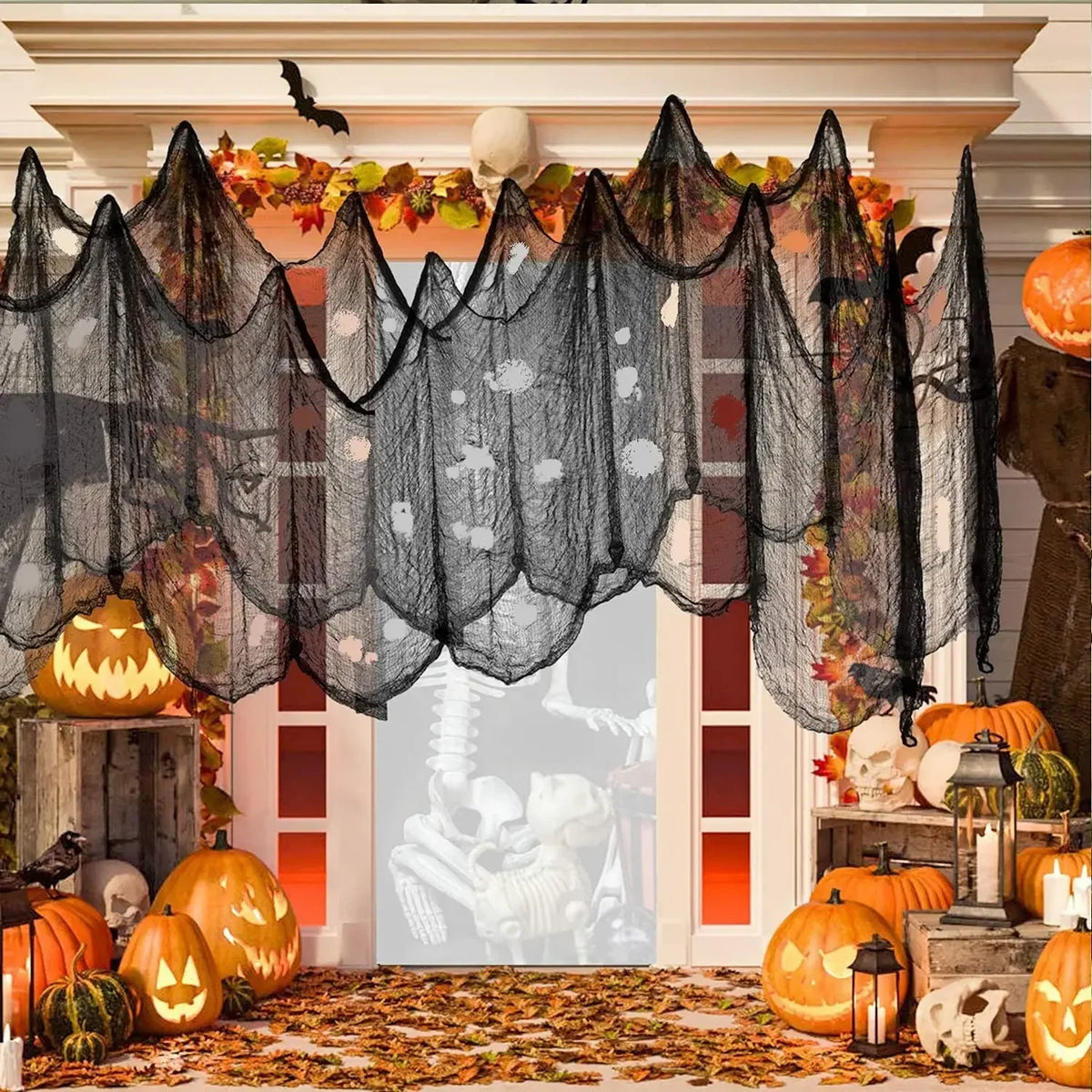 Black creepy gauze cloth draped over an orange floral garland for Halloween decor