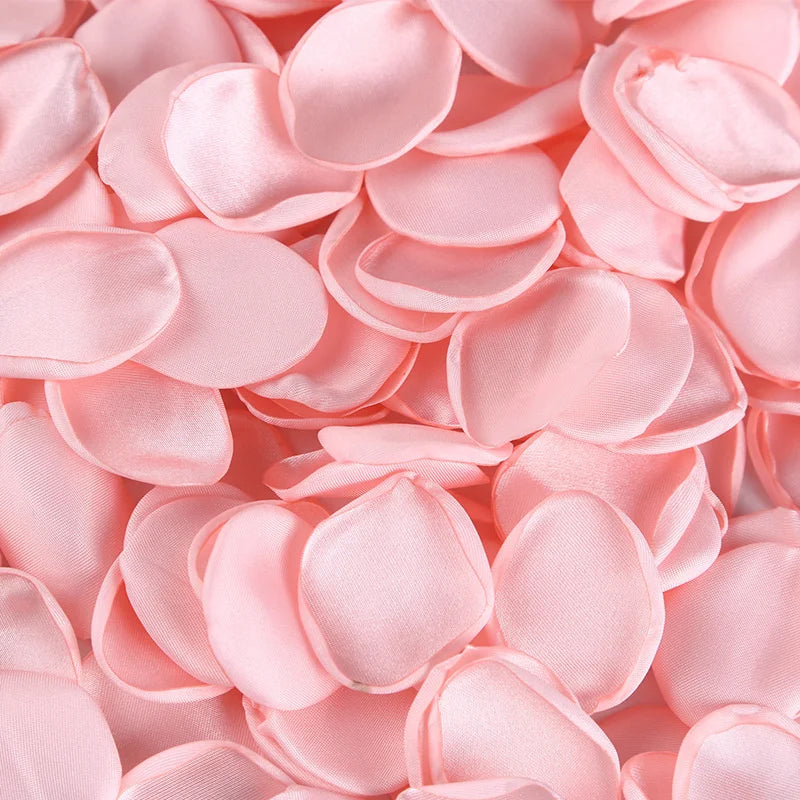 Pink silk rose petals scattered in a pile for weddings and events