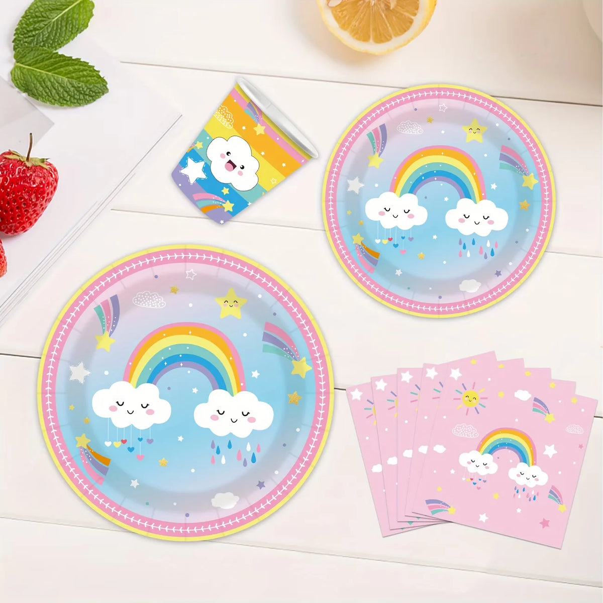 A set of colorful disposable paper plates, cups, and napkins featuring rainbows and clouds for a party theme.