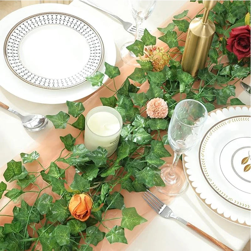 A table setting featuring a plate, silverware, and a green ivy vine garland on a wooden surface.