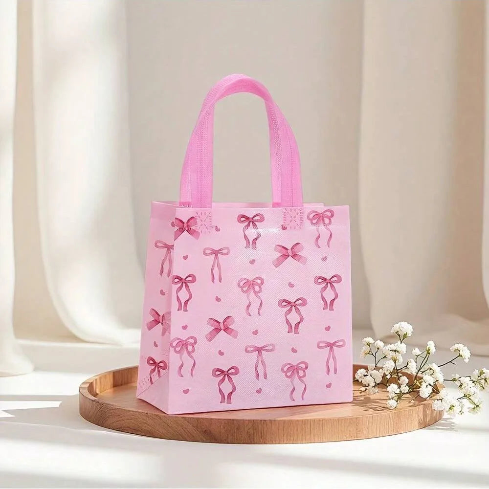 Pink gift bags with white heart cutouts displayed on a wooden tray