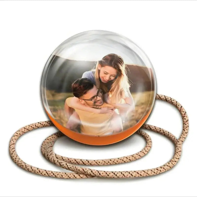 A clear glass crystal ball with a photo inside, surrounded by coiled cord.
