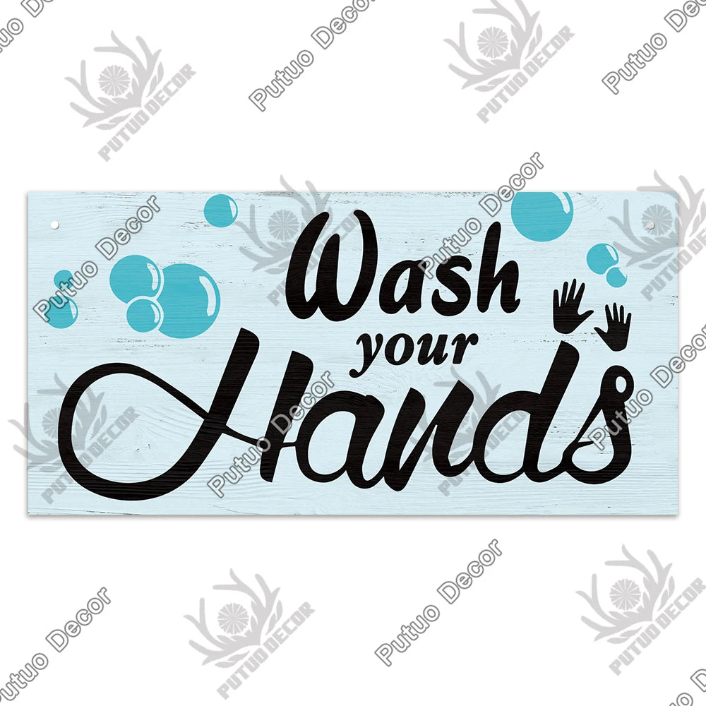 Rustic wooden sign with black text that reads Wash your hands, featuring light blue and teal accents.