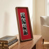 A wooden photo strip frame with a red background displaying several small photographs.