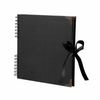 Bloc-notes album photo noir à plat avec couverture bordée d'or et attaché avec un ruban noir.