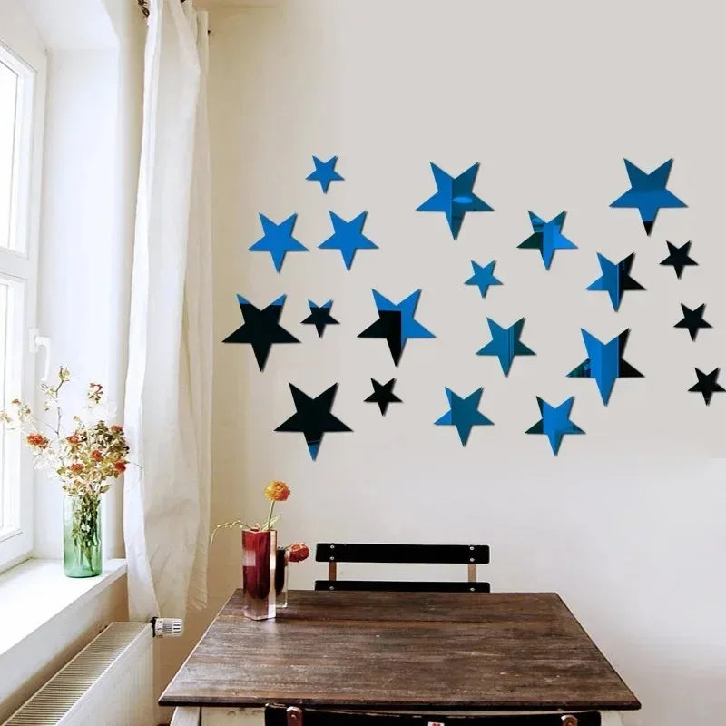 A wall display of blue and black star-shaped acrylic mirror decor on a white wall next to a window.
