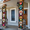 A vertical banner featuring colorful Day of the Dead skulls and flowers displayed in a porch entryway.