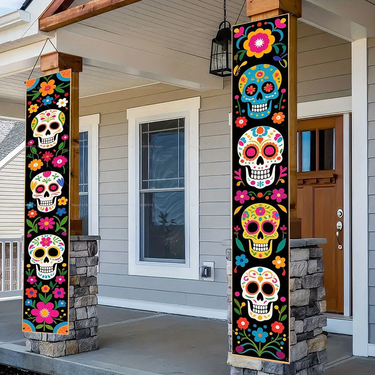 A vertical banner featuring colorful Day of the Dead skulls and flowers displayed in a porch entryway.