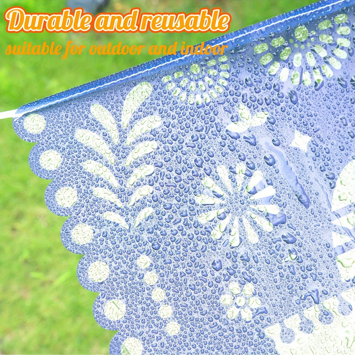 Blue papel picado bunting decorated with white cutouts, showing water droplets on the fabric.