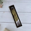 A package of elegant spiral birthday candles with long thin wicks displayed on a white wooden surface.