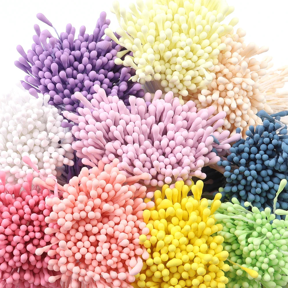 A collection of mini artificial flower stamens in various shades including purple pink yellow and green