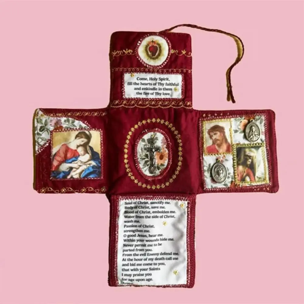 A handcrafted pocket devotional with a cross-shaped pouch made of deep red fabric and gold embroidery.