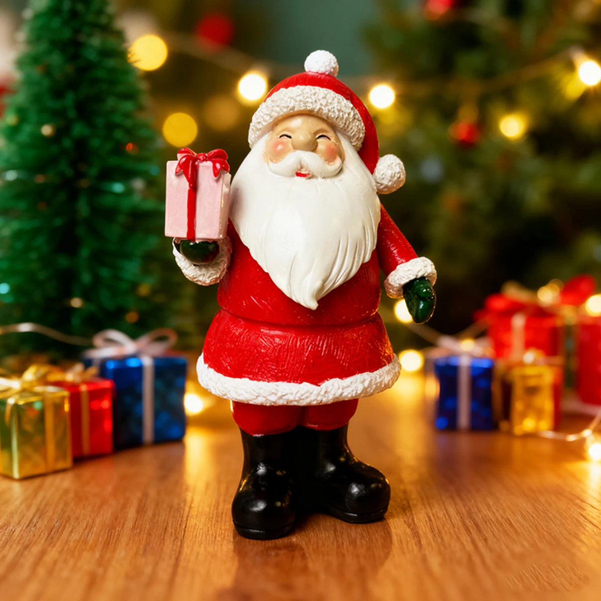 Adorno de Santa Claus de resina con barba blanca y traje rojo sosteniendo un regalo, contra un fondo desenfocado de árbol de 