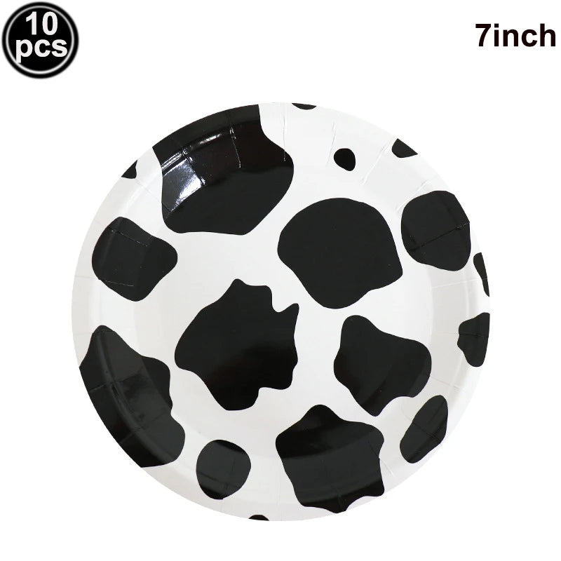 A white plate decorated with black cow print spots, suitable for farm-themed parties.