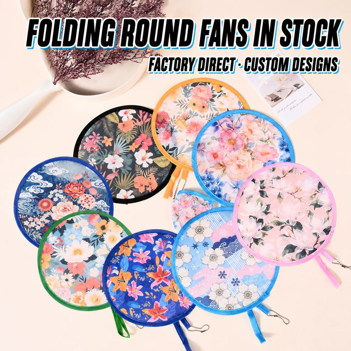 A collection of round folding fans in various floral and patterned designs are displayed on a light background.