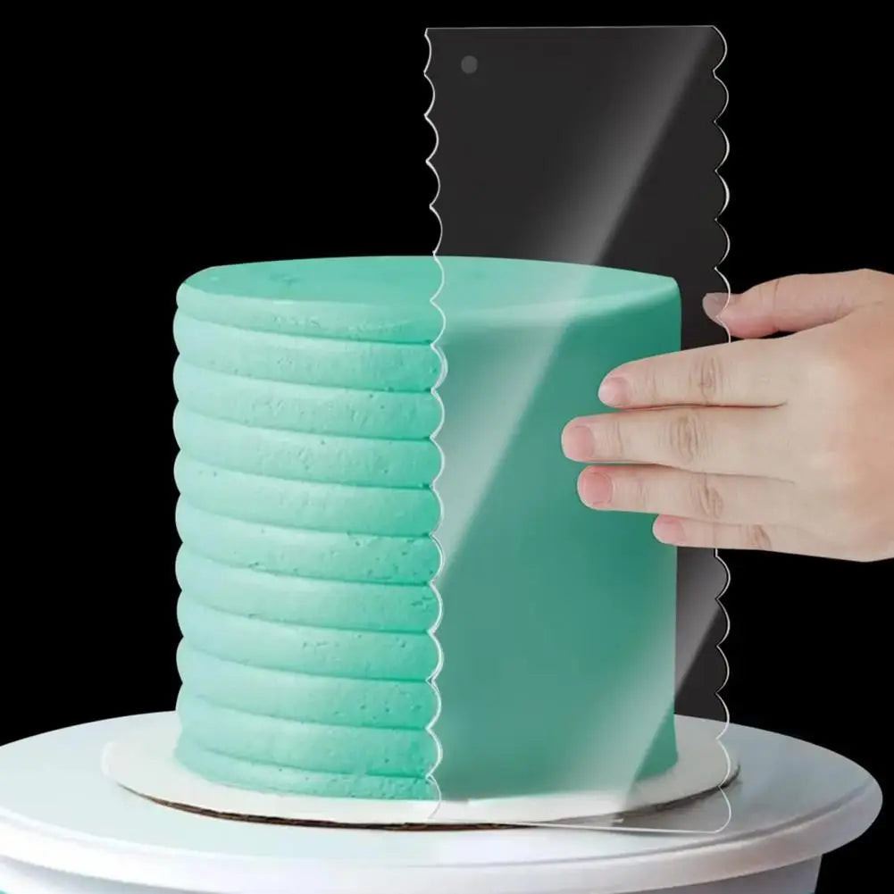 Eine Hand hält einen Stapel von sechs hellminzgrünen Acryl-Kuchenschabern über einem gefrosten Kuchen.