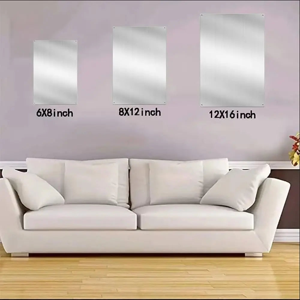 Un sofá está colocado frente a una pared decorada con tres letreros rectangulares de color plateado enmarcados.