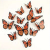 A set of twelve orange and black monarch butterfly decals scattered on a white background.