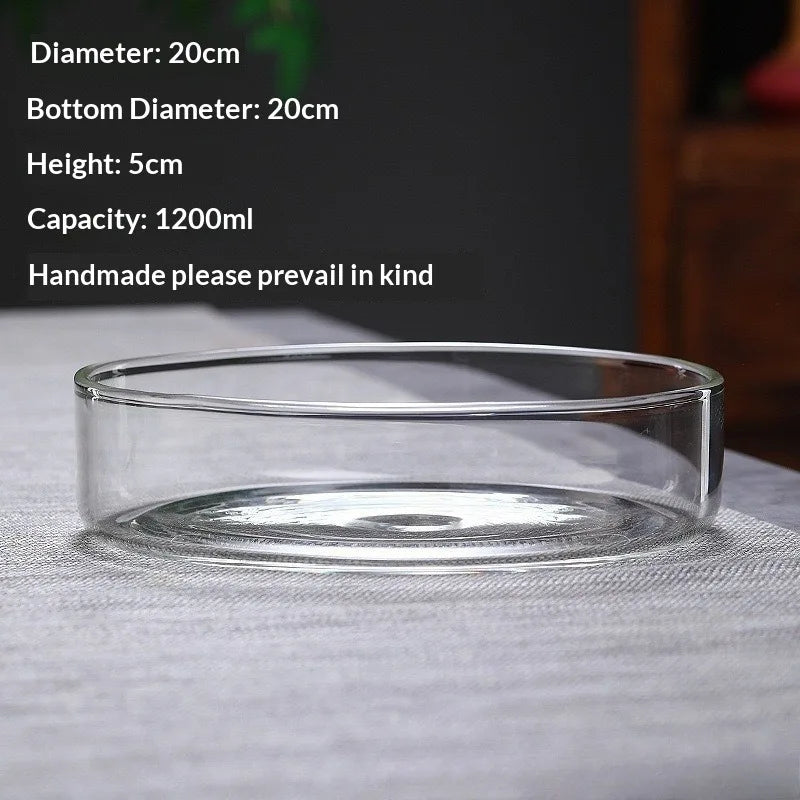 A clear glass bowl or vase is shown on a gray fabric, with specifications listed nearby.