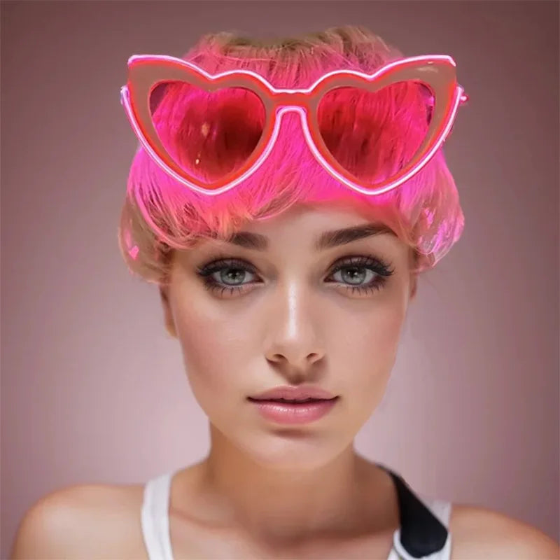 A woman wearing bright pink heart-shaped LED wire party glasses.
