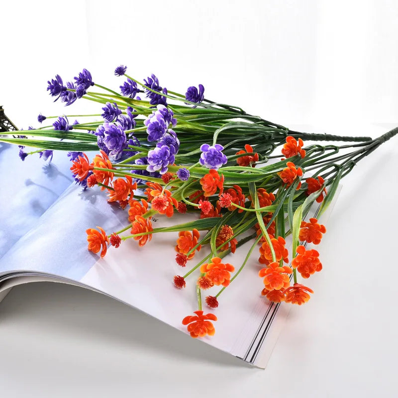 A bundle of purple and orange artificial flowers used for home and event decoration.