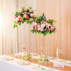 Vases centraux en acrylique élégants avec des fleurs roses et blanches, présentés sur une table.