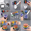 A collection of handmade candle wax kits showing various colors and textures of sand pigment in glass jars and on a white sur
