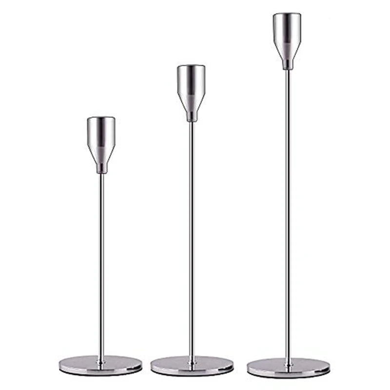 A set of three elegant metal candle holders with slender, polished silver-toned stems and round bases.