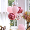 A bouquet of pink and peach balloons arranged on a white stand for party decorations.
