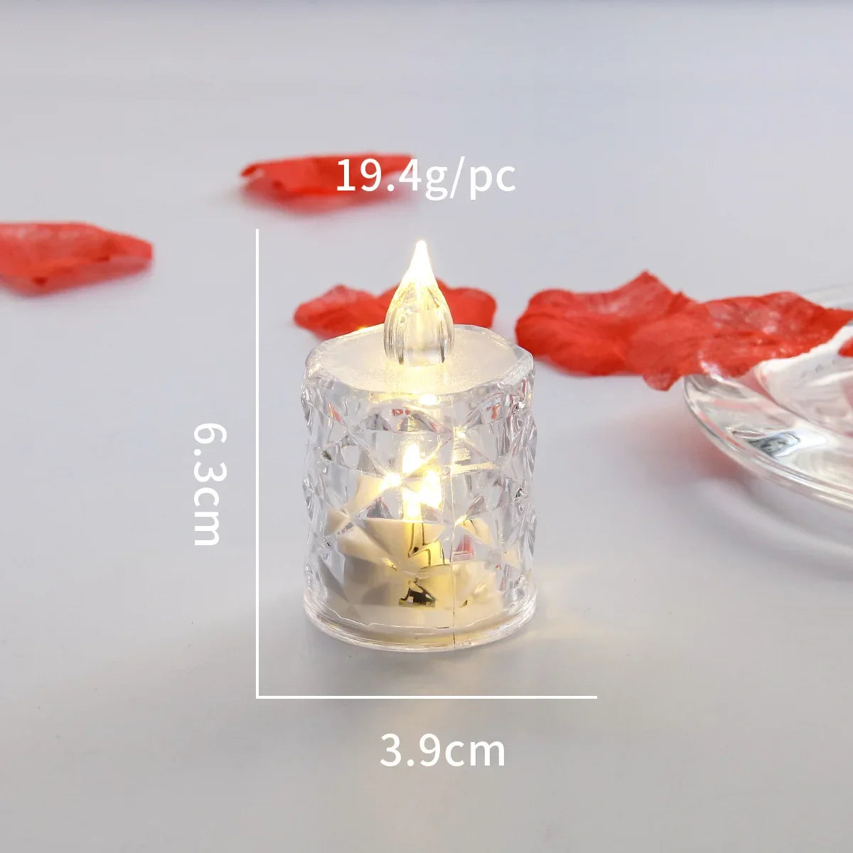 A clear crystal candle in a glass holder with a flickering LED light, surrounded by dried red fruit pieces.