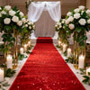 Elegant white sparkling aisle runner with red carpet and floral decorations for a wedding ceremony.