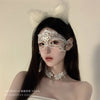 A woman wearing an elegant white lace masquerade eye mask and a fluffy white headband.