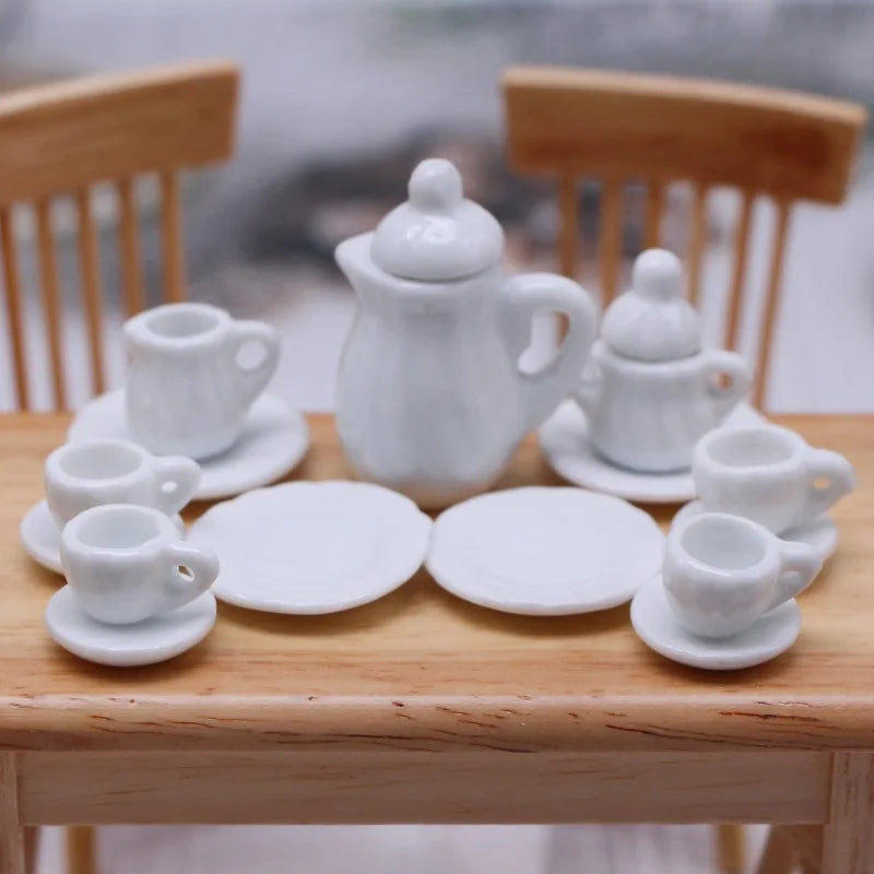A 15-piece miniature white porcelain tea set for a dollhouse displayed on a wooden table.