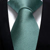 A teal striped silk necktie tied in a knot against a black suit jacket.