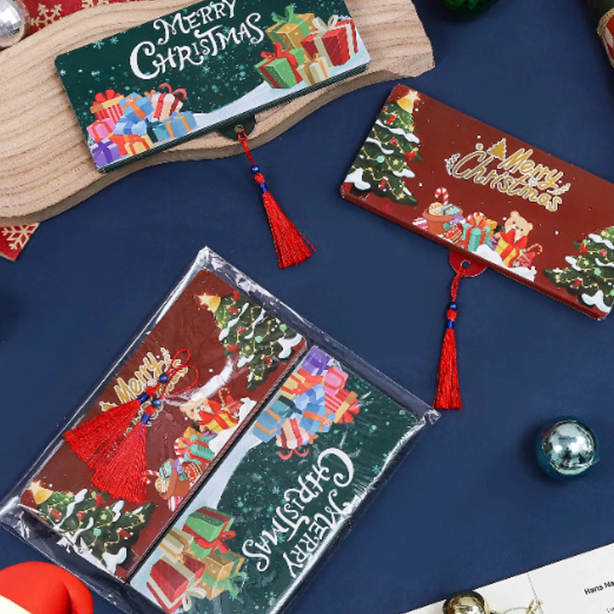 A festive cash gift box with Christmas designs and red tassels is displayed on a dark blue surface.