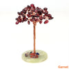 Natural crystal money tree decor featuring deep red beads on a copper wire stem and green base