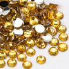 A pile of round, flatback resin rhinestones in a golden yellow color.