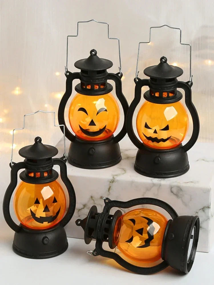 A set of black pumpkin lanterns with glowing orange LED faces displayed on a white marble surface.